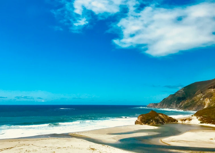 a picture taken on the beach with water coming up the side