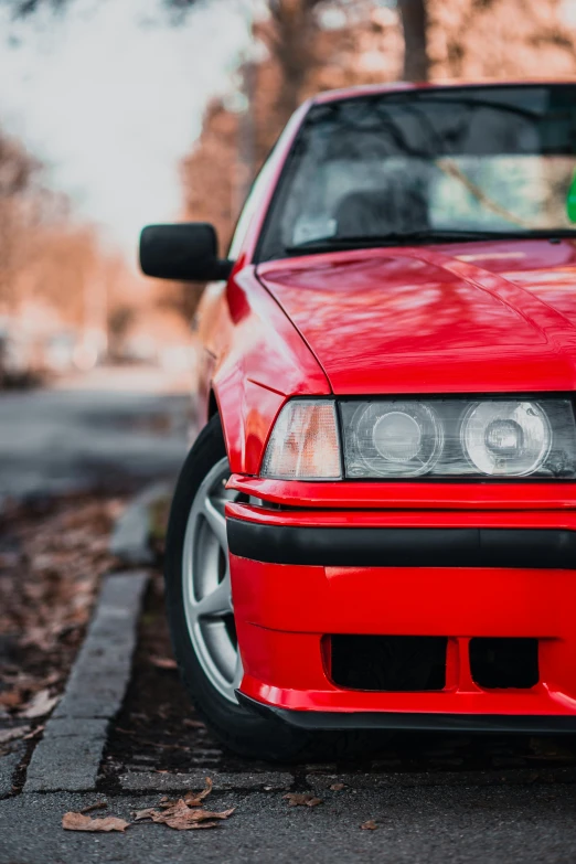 the front end of a red car on the street