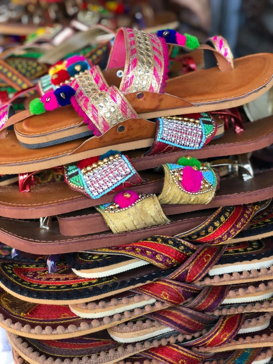 many colorful sandals stacked on top of each other