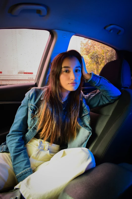 a woman sitting in the back seat of a car