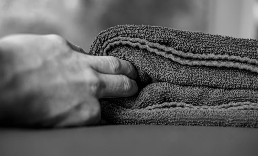 a person touching the edge of some folded towels