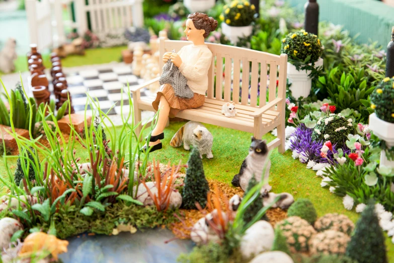 a small garden is shown with miniature figurines on display