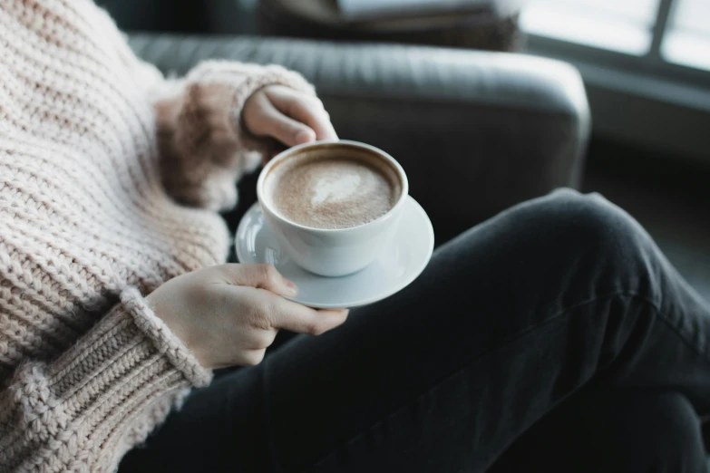 a close up view of a person holding a cup of coffee