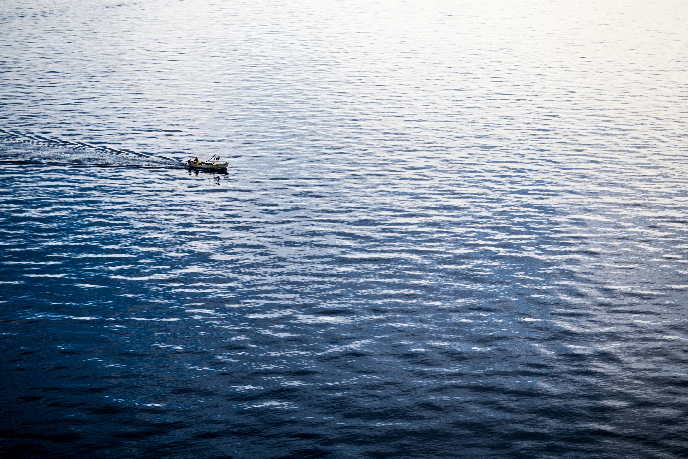 the lone boat is floating in the middle of a lake