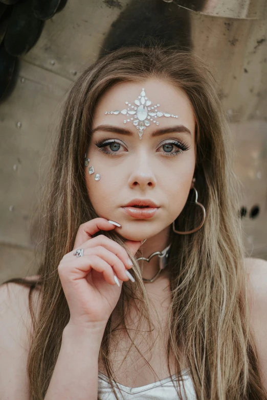 the woman has her hands on her face and is wearing silver jewelry