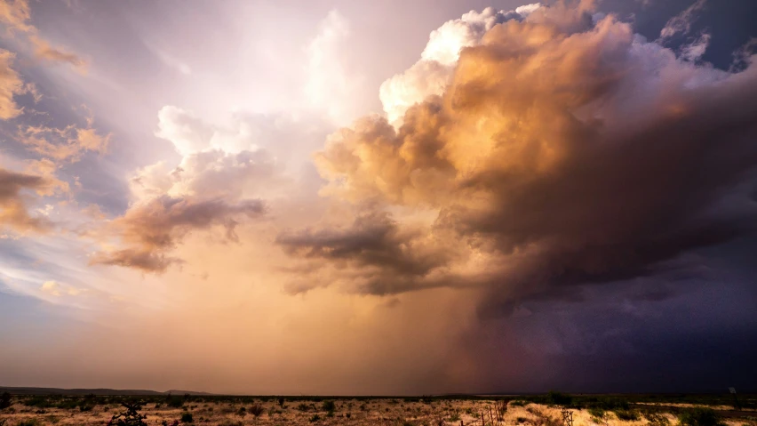 a view of clouds and a large grass area