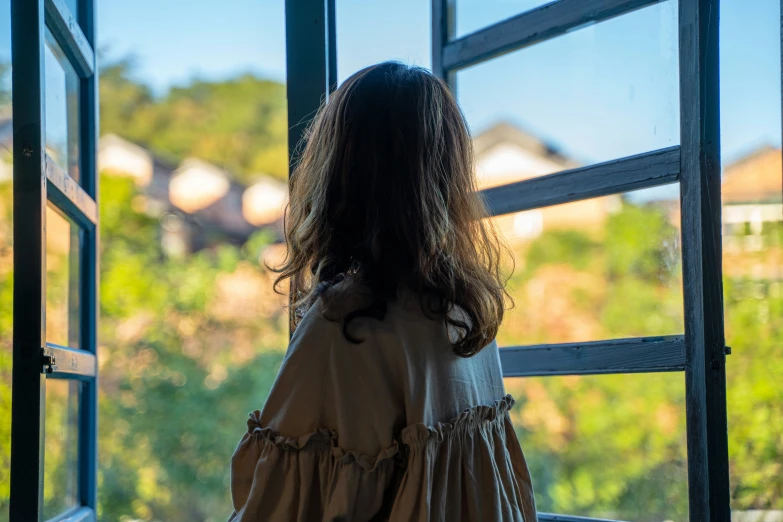 a lady standing and looking out of a window