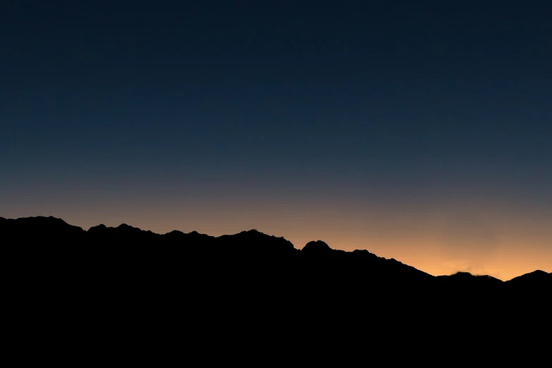 a plane flying through the sky above mountains