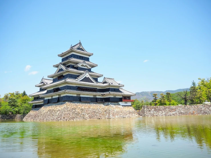 the pagoda is built on top of a small hill in front of the water