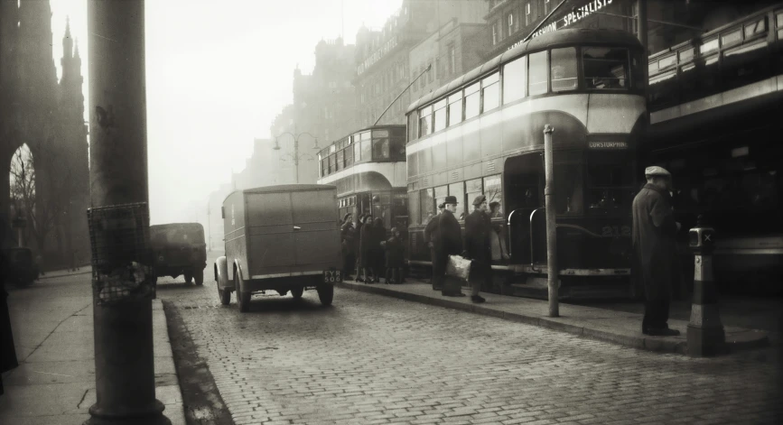 some men are standing on the sidewalk by some buses