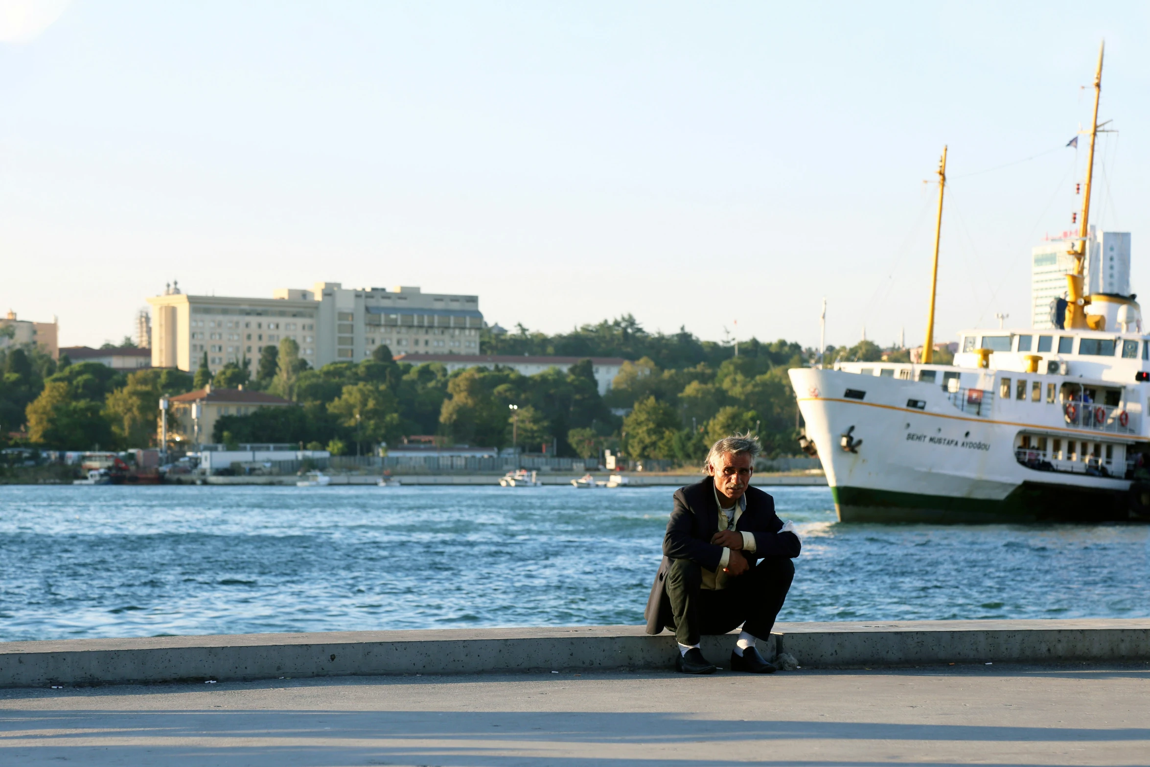 a person sitting on the ground near the water