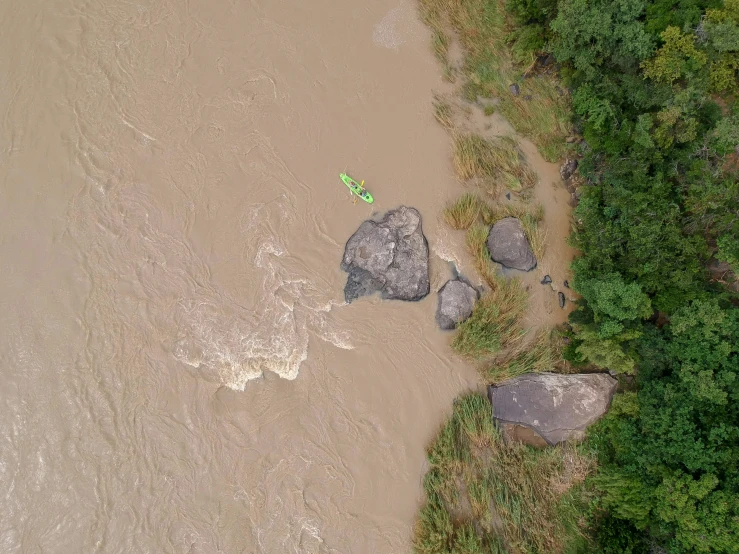 there is a green boat floating in the river