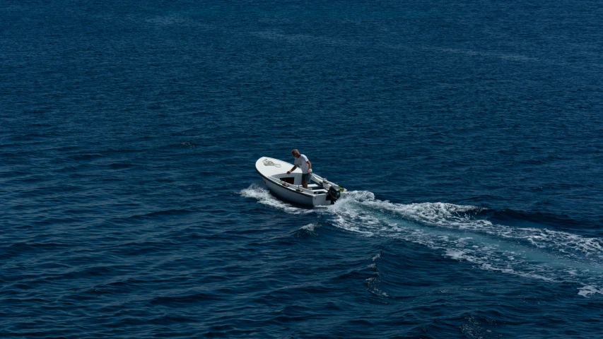 a man in a motor boat speeding along the ocean