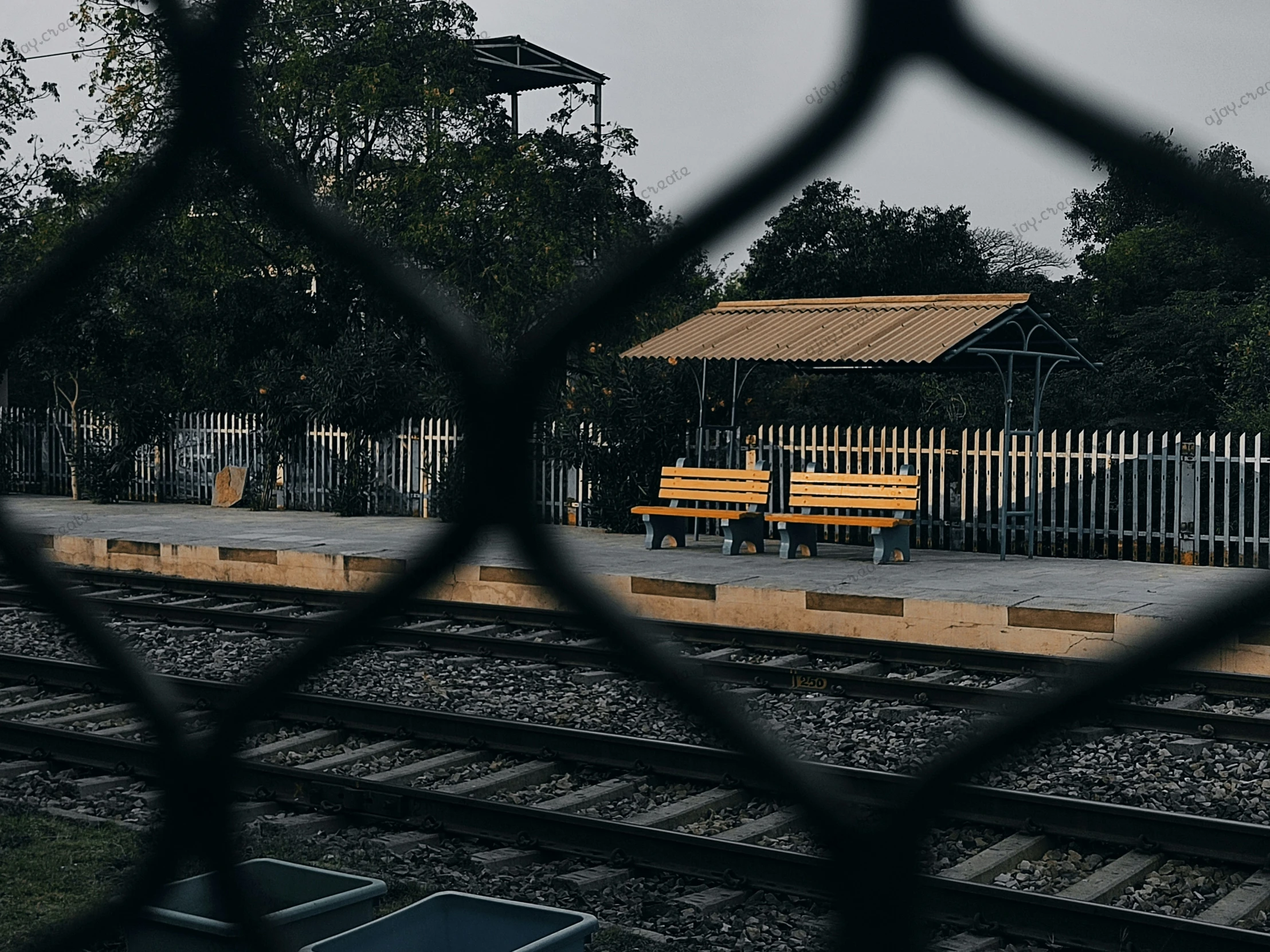 the yellow bench is in the middle of the train tracks