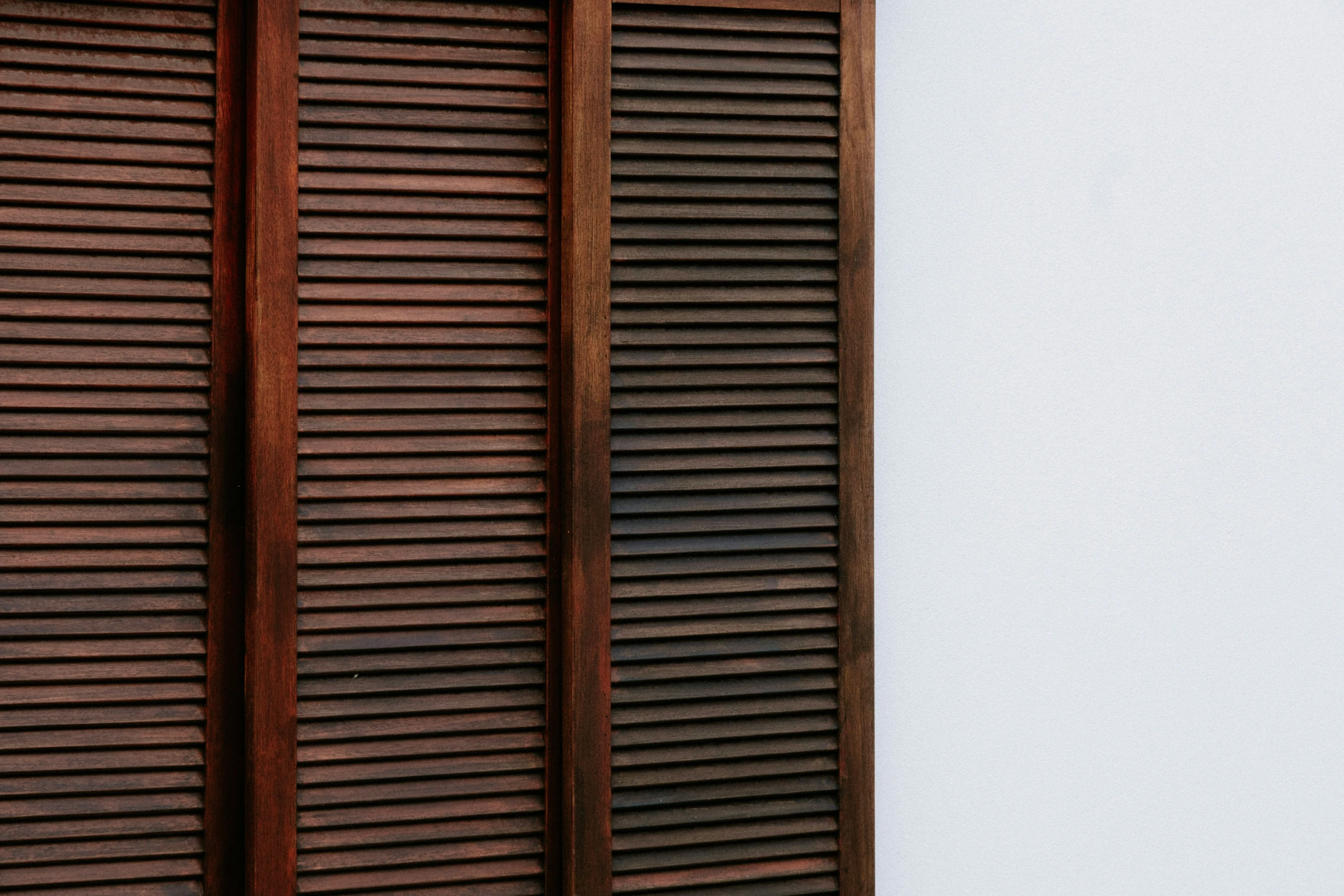 an old style window has closed wooden blinds