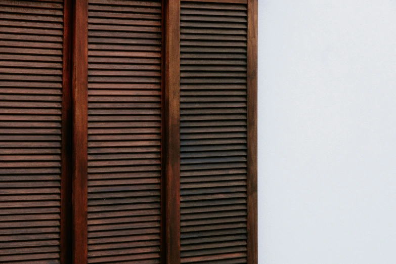 an old style window has closed wooden blinds