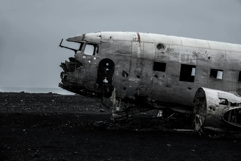 an old plane sitting on top of a black field