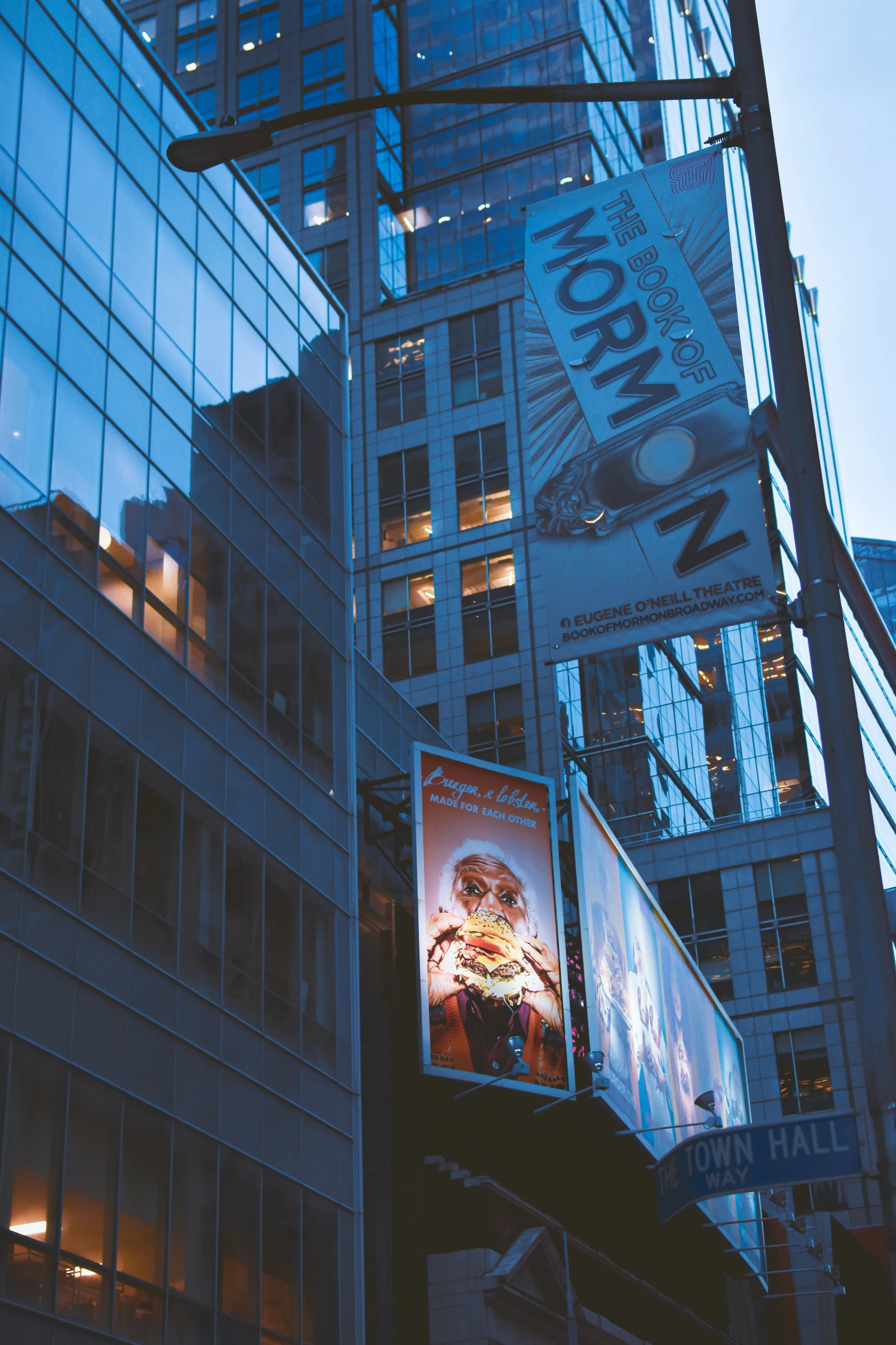 a billboard is hung from a pole by buildings