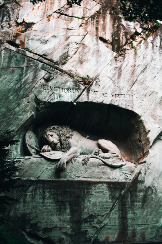 a stone sculpture of a lion resting in a trough