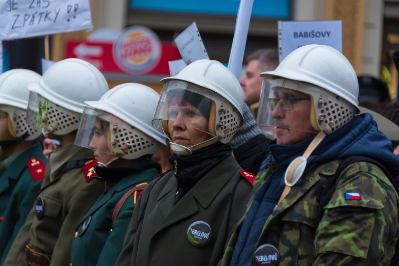 people are standing together wearing white helmets and holding signs