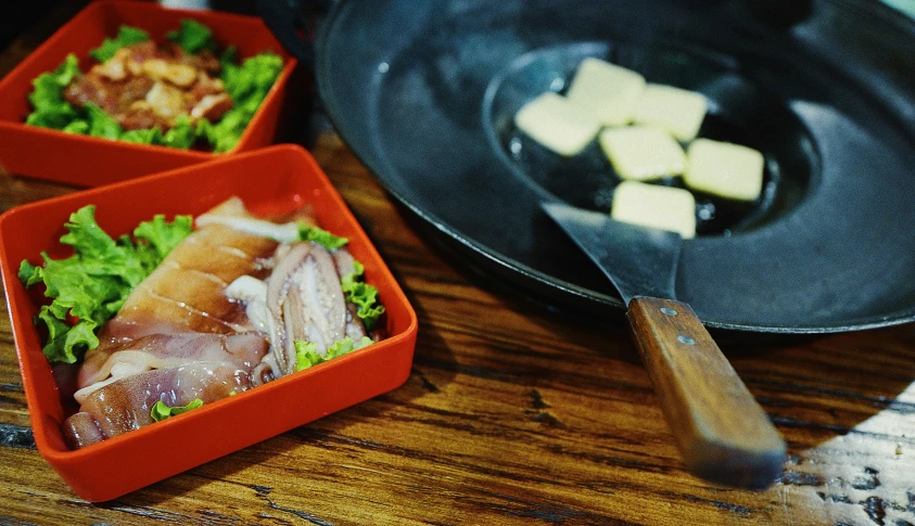 two bento style dishes one is filled with food and the other contains sushi