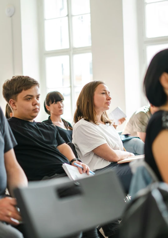 many people in rows listening to each other at a conference