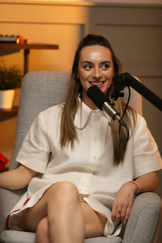 a woman is sitting on a chair with a microphone