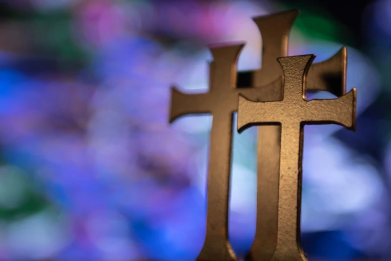 a golden cross is in the middle of some blurred background