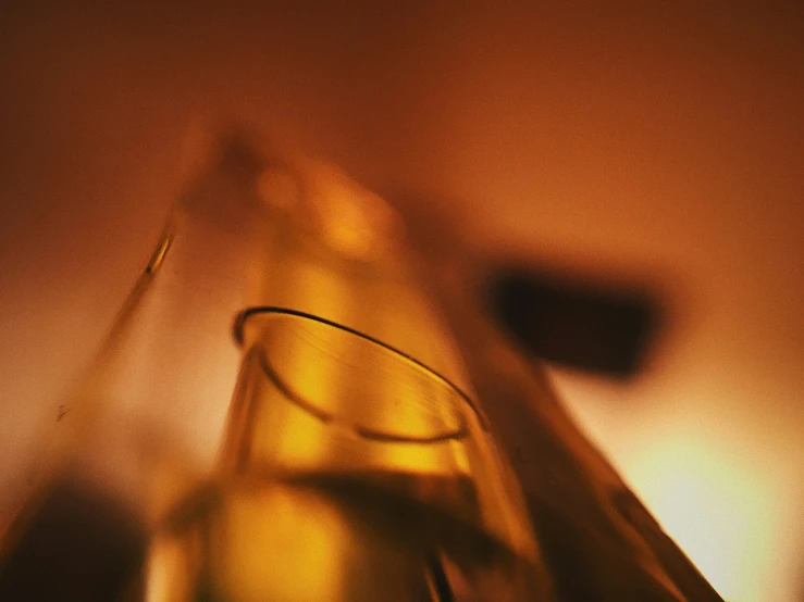 a brown bottle and a glass on top of a table