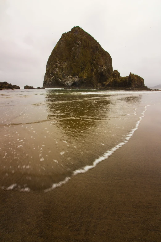 a rocky cliff on an ocean beach near the water