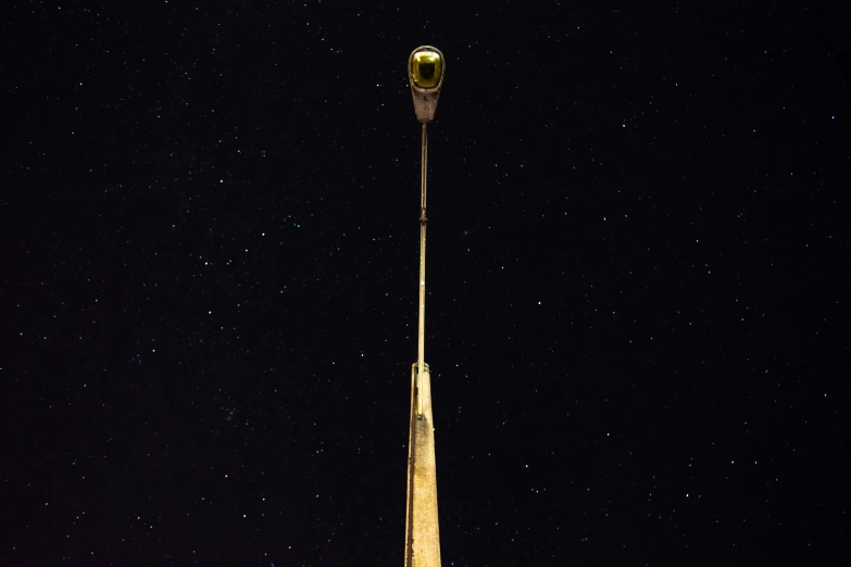 a tall clock tower lit up with the stars in the sky