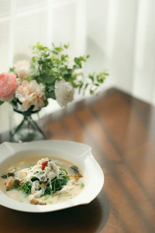 a bowl filled with vegetables next to flowers