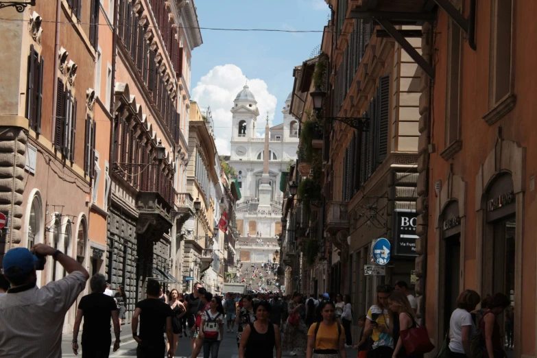 people walk through a street in an old european city