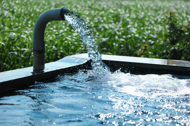 a jet is spraying water over an open pool