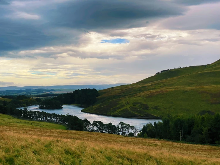 a lush green valley with a river running through it