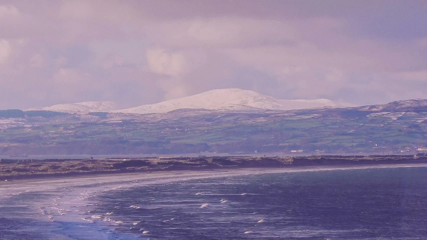 a person standing on the beach flying a kite