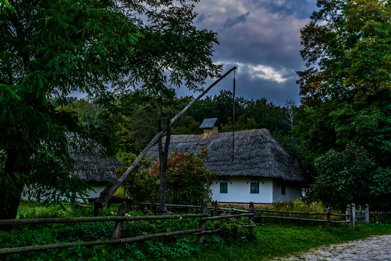 a white cottage with thatched roof and trees