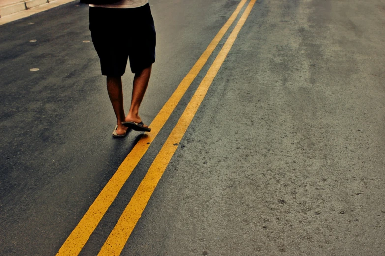 the person is walking down the street with one foot in the street