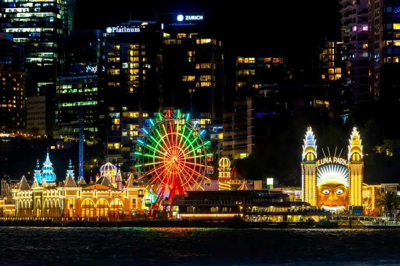 the large ferris wheel has lights on it in a city