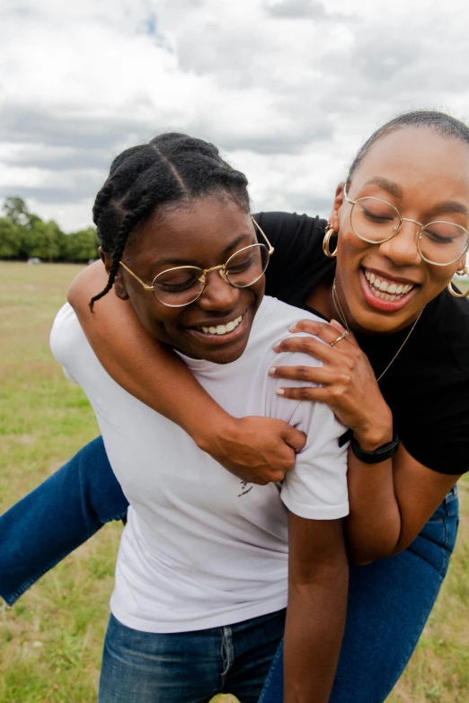 two women emcing and laughing in a field