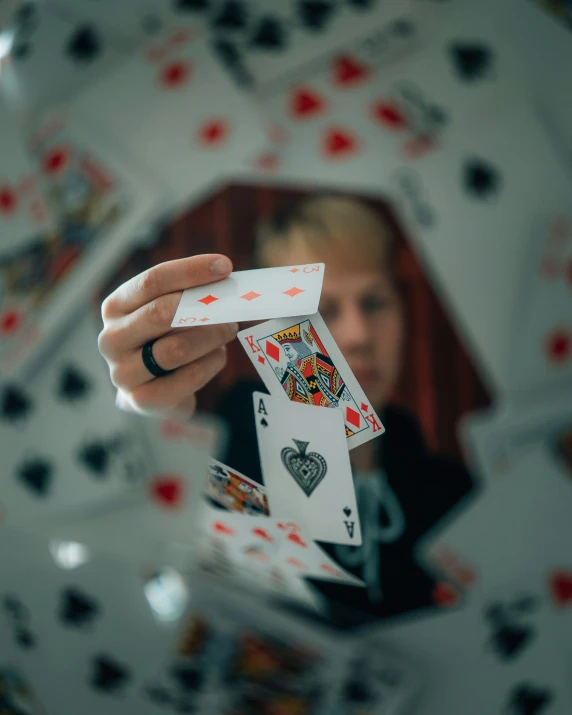 a girl holding up playing cards in her hands