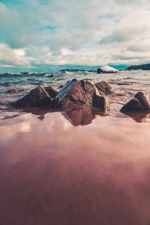 a group of rocks sitting in some shallow water