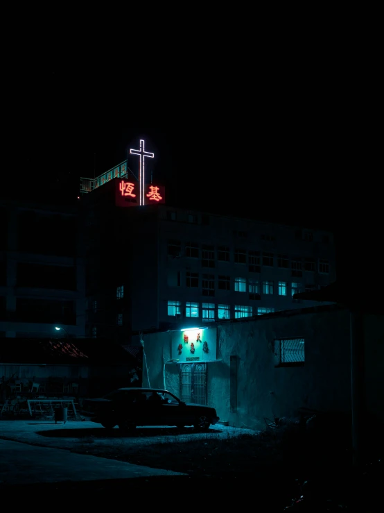 the night scene shows a building with cross lights in front