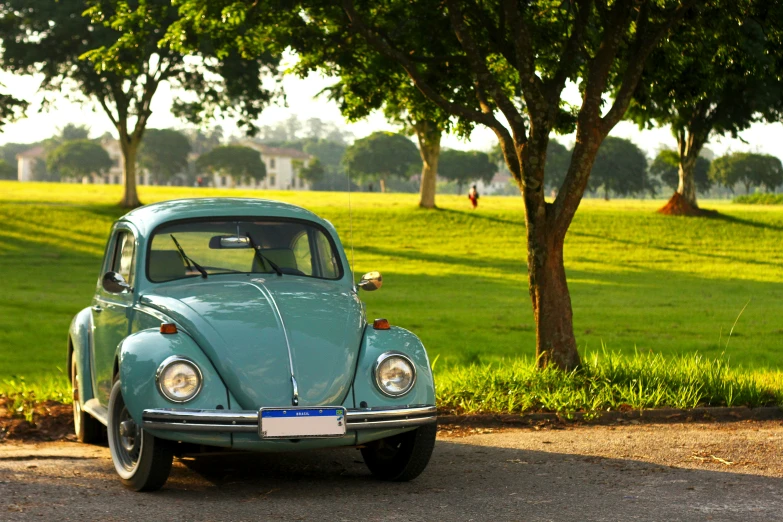 an old, blue beetle parked on the side of the road