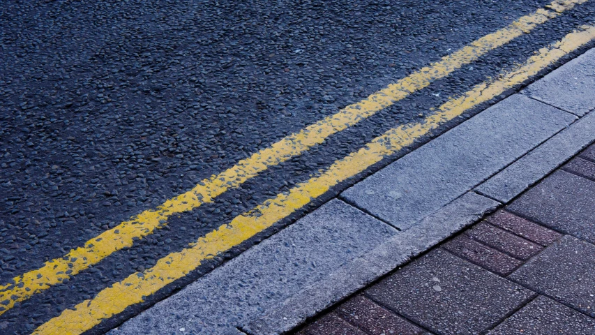 a sectioned road that is being painted with bright yellow paint