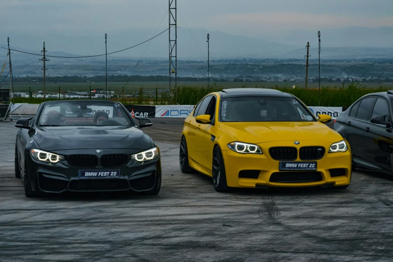 a group of three cars driving around an outdoor track