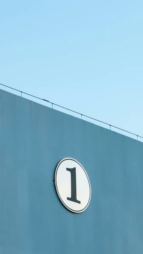 a round metal sign on the side of a building