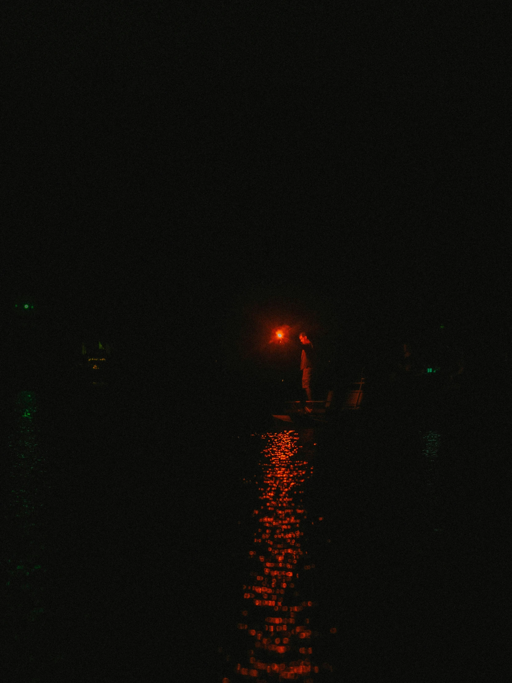 the street light glows brightly at night, along with its dark backdrop