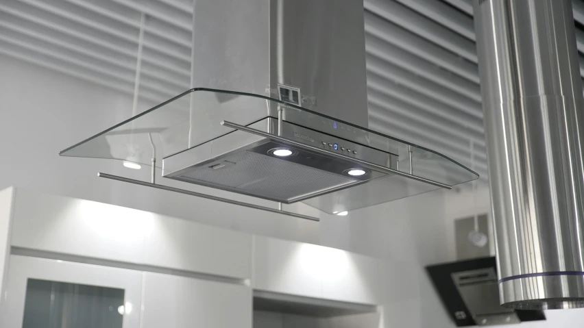 a modern kitchen hood suspended from the ceiling above it