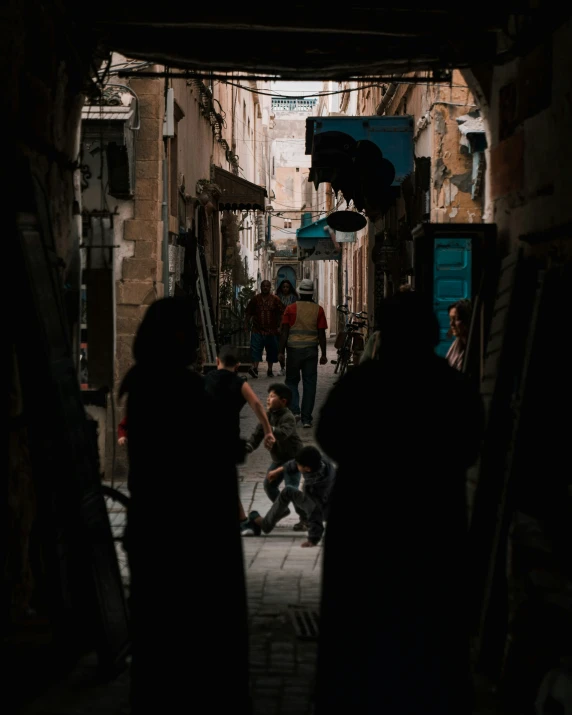 people walking through an alley way at night